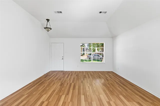 a view of room with a window and wooden floor