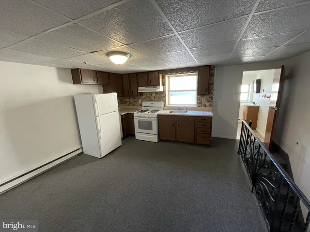 a kitchen with a sink a stove and cabinets
