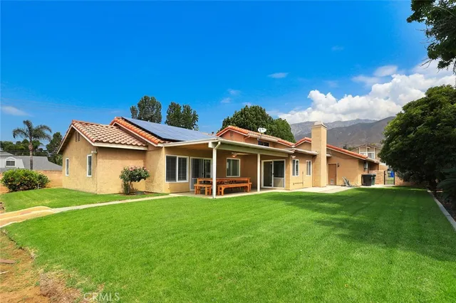 a front view of a house with a garden and trees