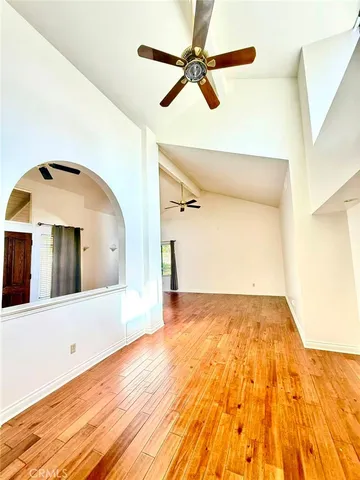a view of a big room with wooden floor and windows