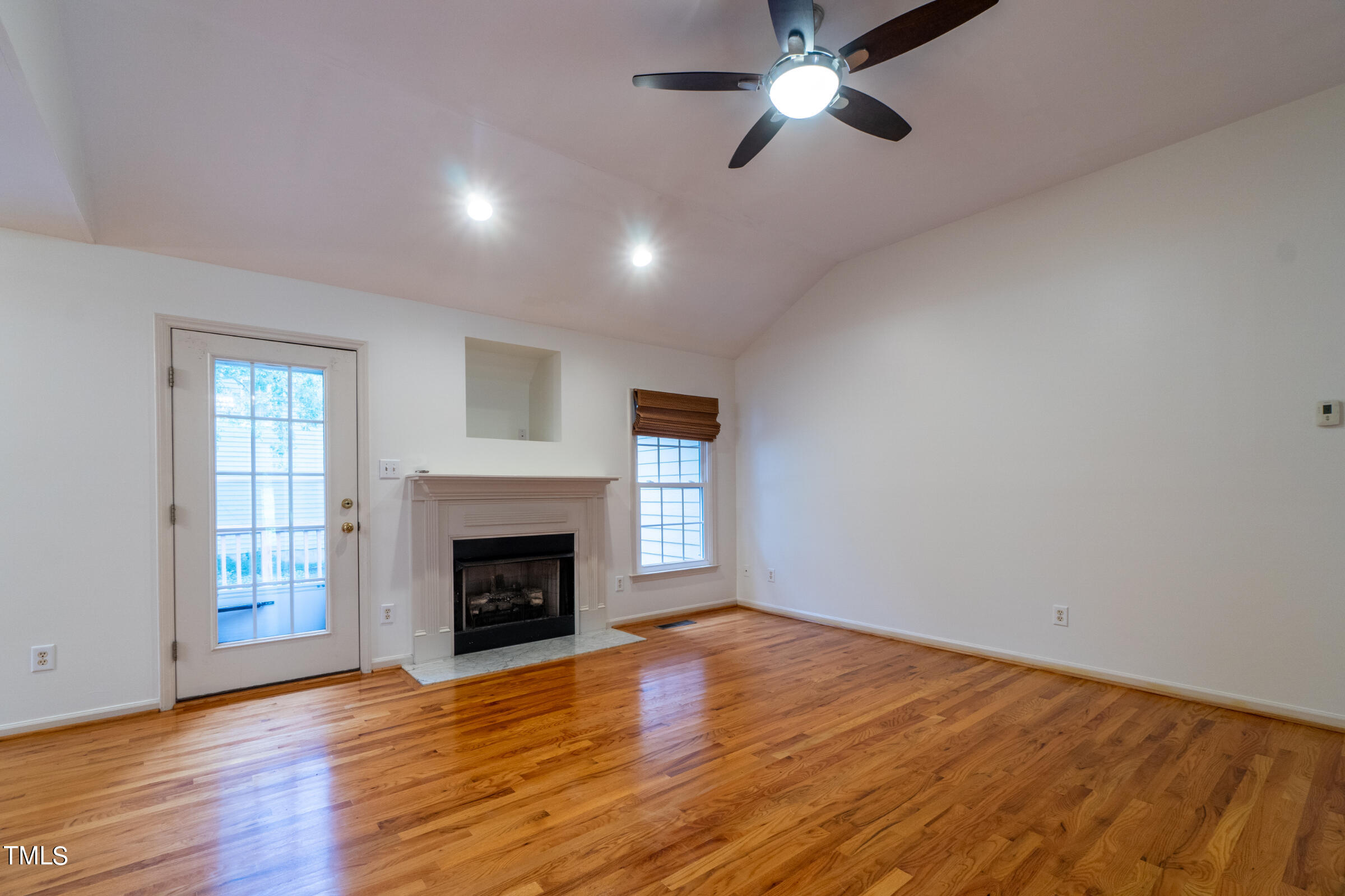 2 Summer Ridge Durham, NC 27712 - Photo 5 of 29 a view of an empty room with wooden floor fireplace and a window