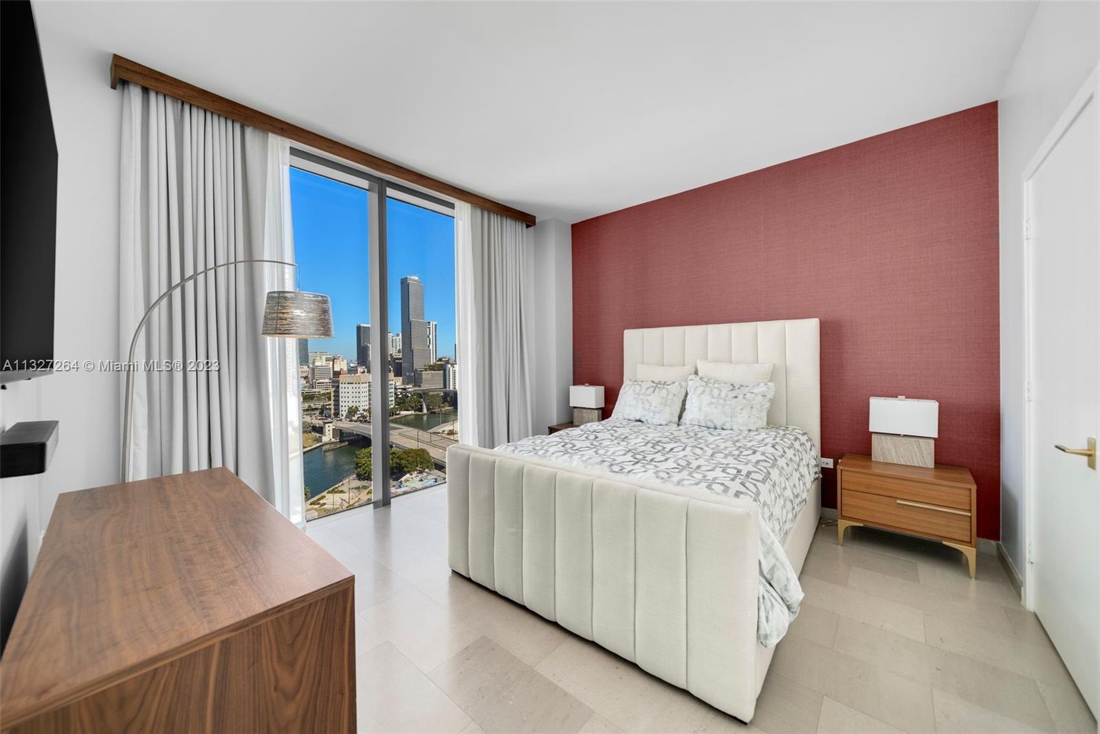 88 Southwest 7th Street, Unit 1212 Miami, FL 33130 - Photo 19 of 45 a bedroom with a bed and a flat tv screen