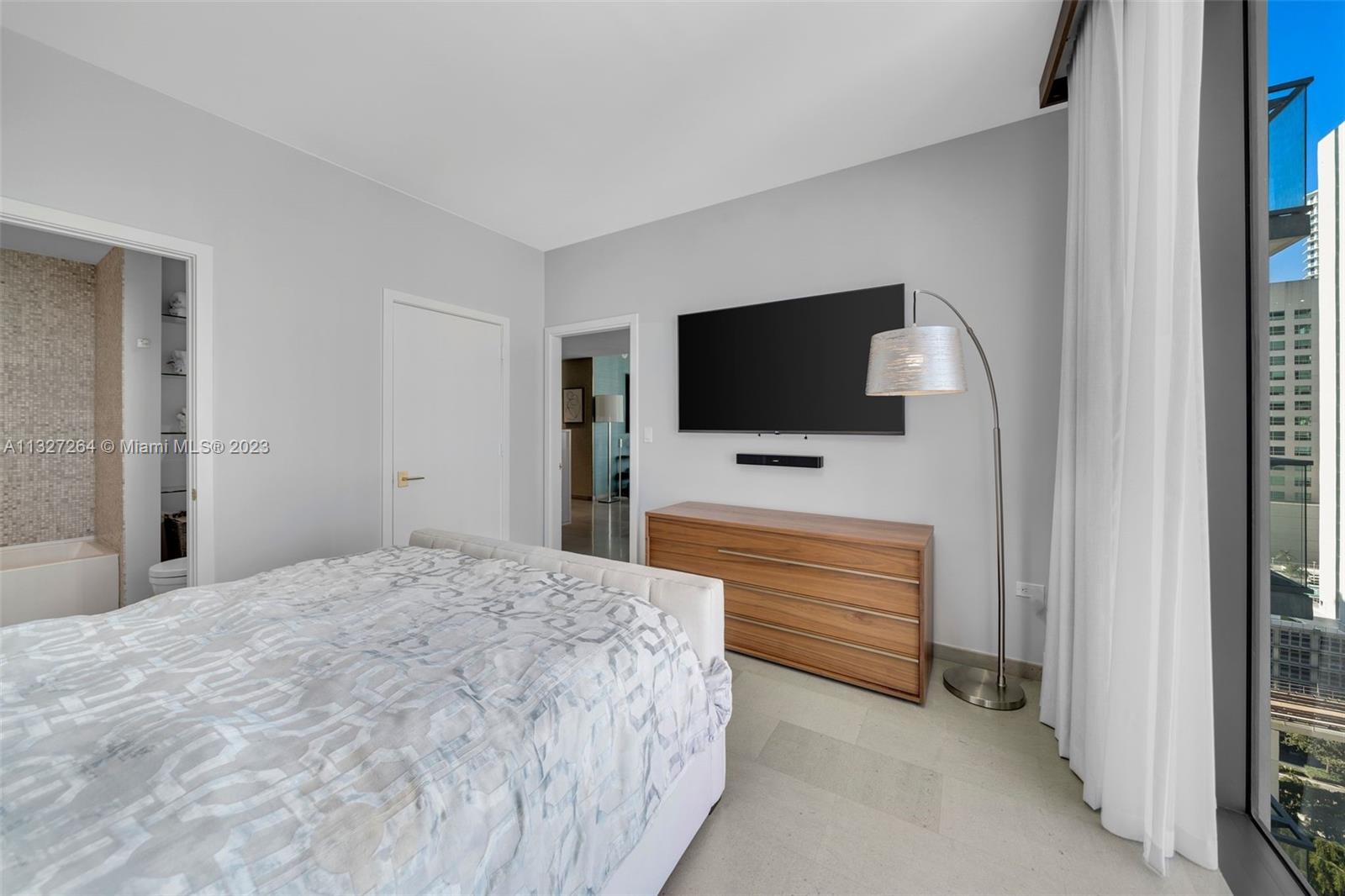 88 Southwest 7th Street, Unit 1212 Miami, FL 33130 - Photo 20 of 45 a bedroom with a bed and a flat screen tv
