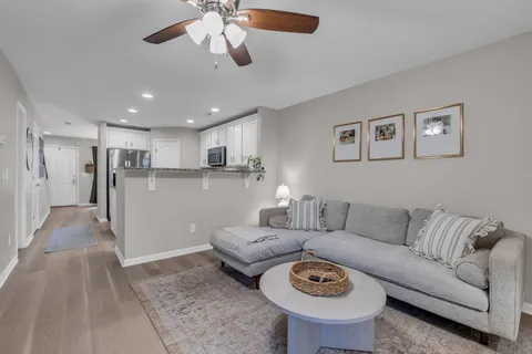 a living room with furniture and a view of kitchen