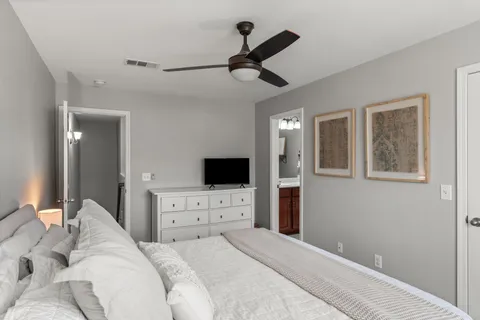 a bedroom with a bed and a flat tv screen on dresser