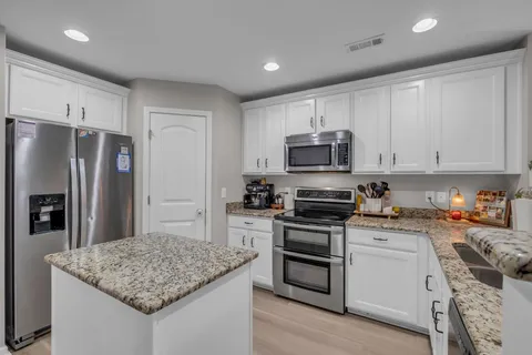 a kitchen with a sink stainless steel appliances and white cabinets