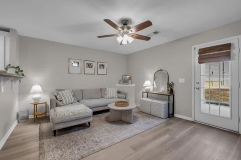 a living room with furniture a chandelier and a window