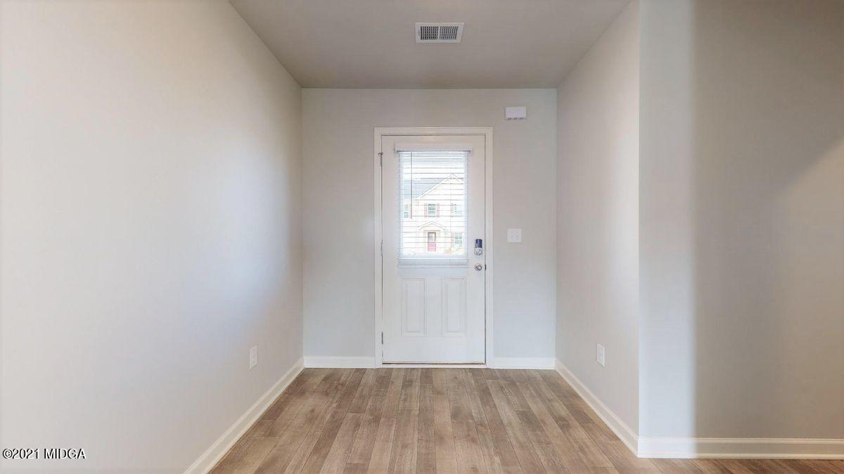 144 Sanders Road, Unit 36 Macon, GA 31210 - Photo 3 of 21 a view of an empty room with wooden floor and a window