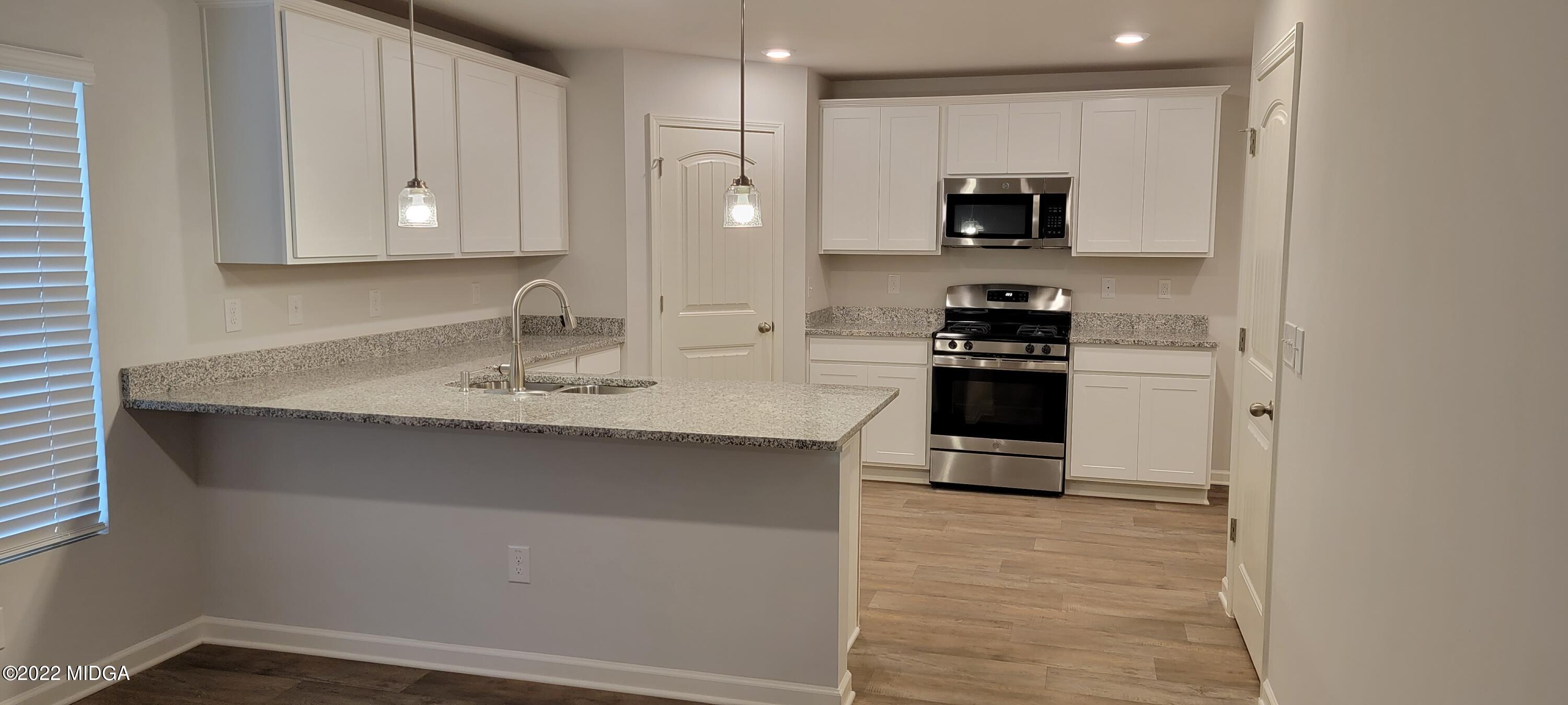 144 Sanders Road, Unit 36 Macon, GA 31210 - Photo 4 of 21 a kitchen with stainless steel appliances granite countertop a stove and a refrigerator