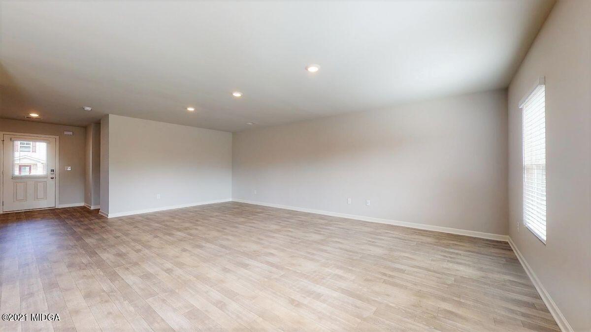 144 Sanders Road, Unit 36 Macon, GA 31210 - Photo 8 of 21 a view of an empty room with wooden floor and windows