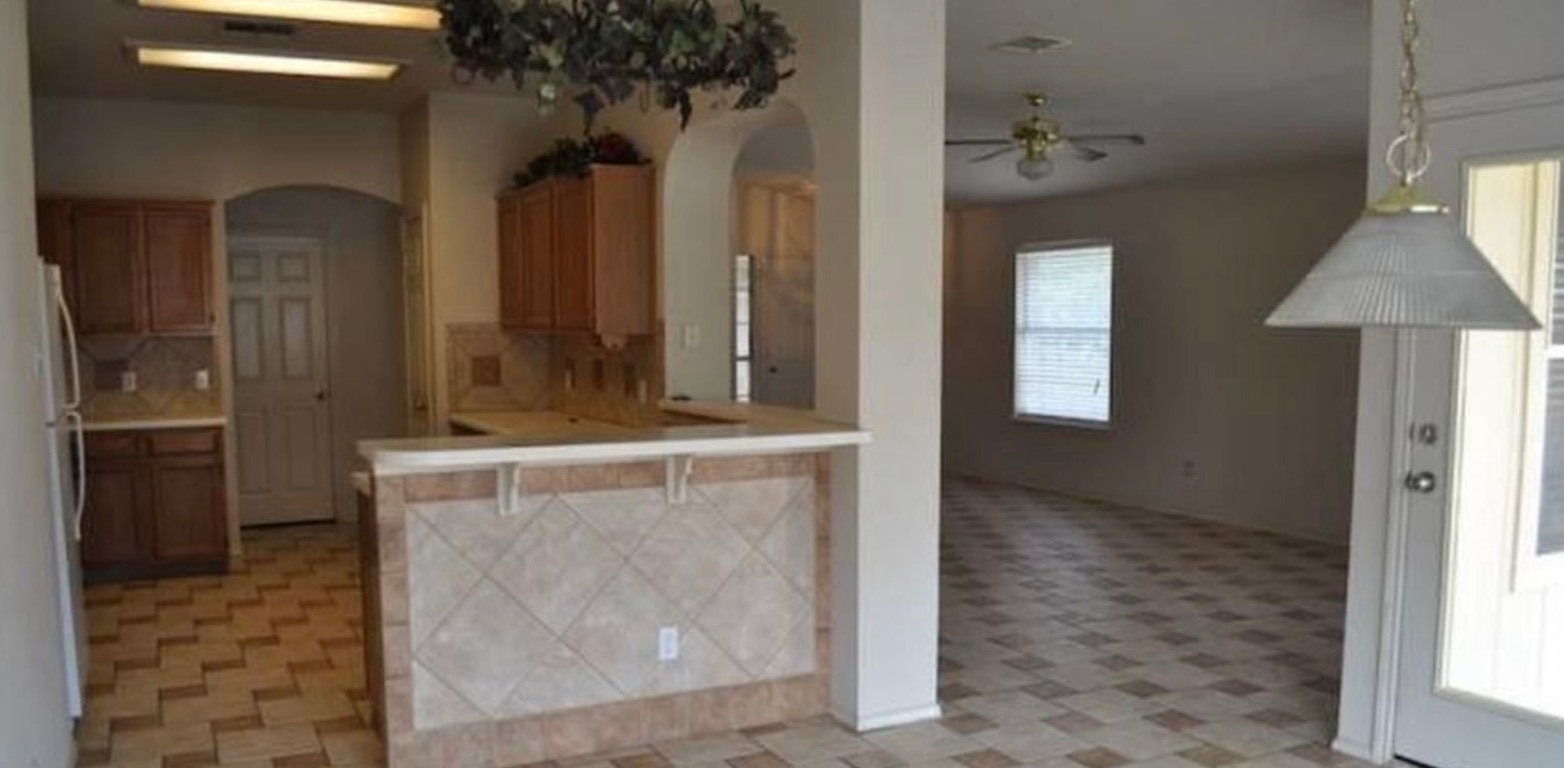 1212 Knoll Ridge Drive Cedar Park, TX 78613 - Photo 10 of 10 Kitchen with light countertops, a kitchen bar, brown cabinets, and open floor plan