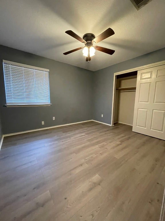 1212 Knoll Ridge Drive Cedar Park, TX 78613 - Photo 8 of 10 Unfurnished bedroom with a closet, light wood-style floors, and ceiling fan