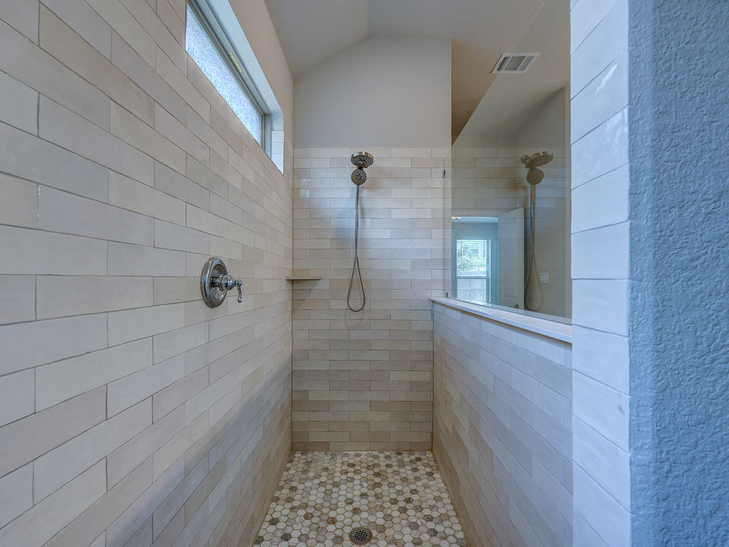 229 Heartleaf Road San Marcos, TX 78666 - Photo 28 of 40 A well-appointed shower space showcases precise tile work and a convenient window for natural light.