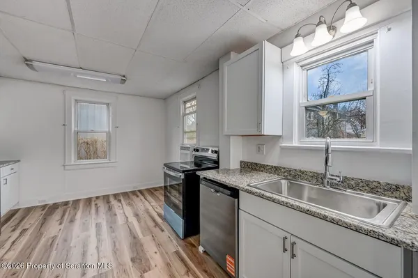 a kitchen that has a sink stove top oven and cabinets