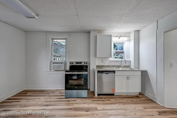 a kitchen with a stove and white cabinets