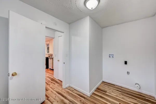 a view of a hallway with wooden floor and entryway