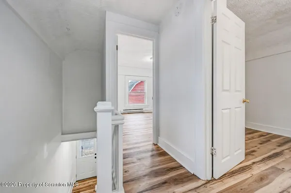 a view of hallway with wooden floor