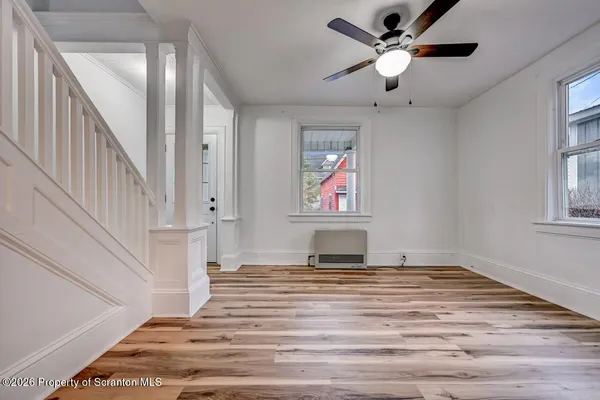 a view of empty room with window and ceiling fan