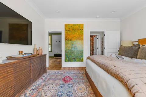 a large bedroom with a bed and a flat screen tv