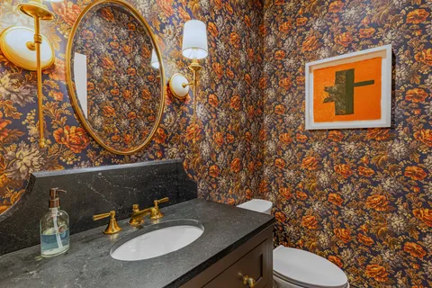a bathroom with a sink toilet and mirror