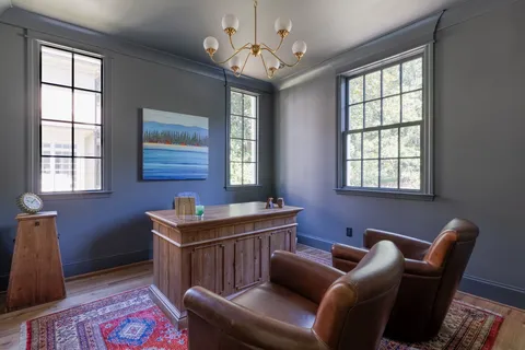 a livingroom with workspace and a window