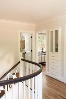 a view of a hallway with wooden floor and staircase
