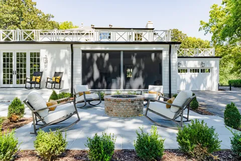 a view of a patio with couches table and chairs and potted plants
