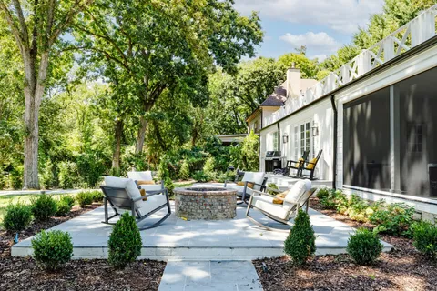 a view of a patio with couches table and chairs and potted plants