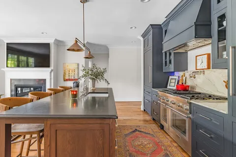 a kitchen with a sink a stove and chairs
