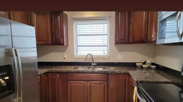 a kitchen with granite countertop cabinets sink and window