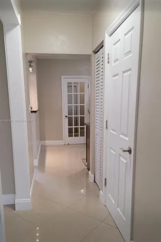 a view of a hallway with wooden floor and closet