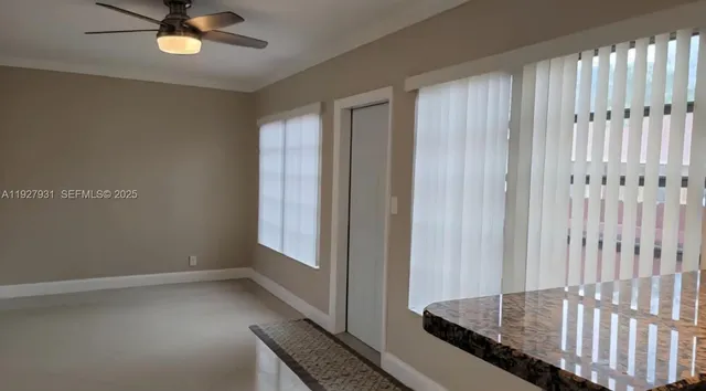 a view of a livingroom with wooden floor and a ceiling fan