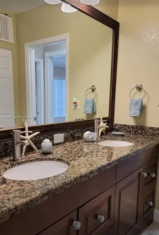 a bathroom with a granite countertop sink and a mirror