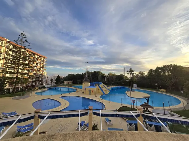 a view of a balcony with chairs and wooden floor