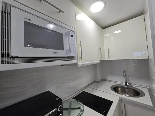 a kitchen with stainless steel appliances a stove a microwave a sink and cabinets