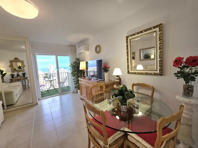 a living room with furniture a chandelier and a potted plant