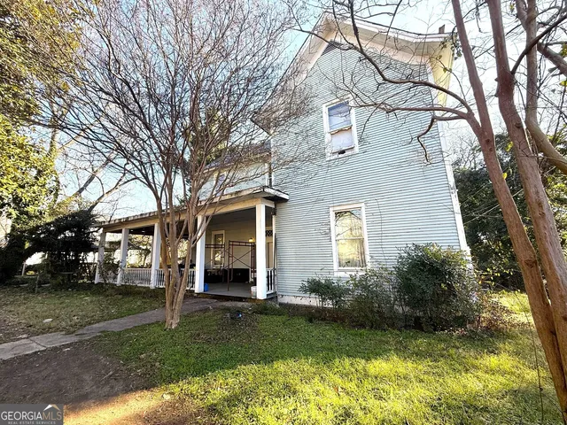 a view of a yard in front of a house with large tree