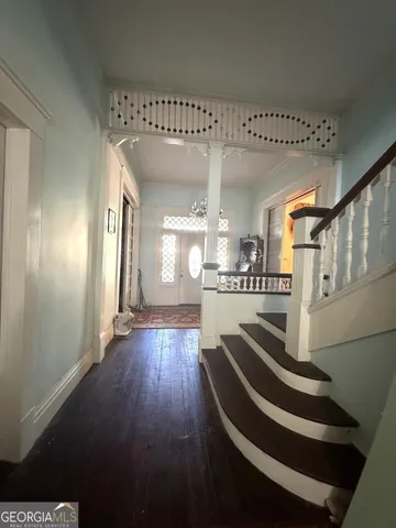 a view of entryway and hall with wooden floor