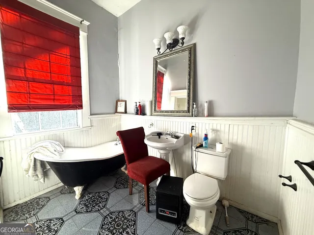 a bathroom with a toilet sink and mirror