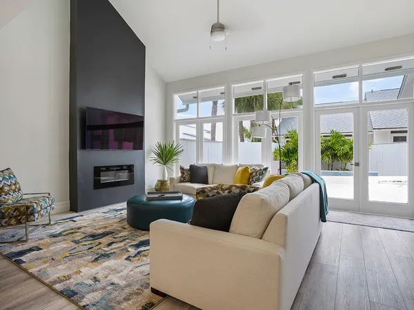 a living room with furniture large window and wooden floor