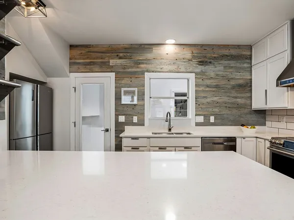 a kitchen with stainless steel appliances kitchen island granite countertop a refrigerator and stove