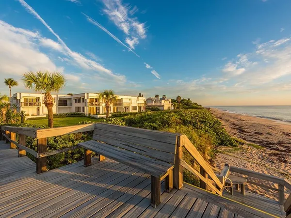 a view of a balcony with wooden chairs