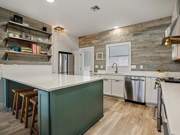 a kitchen with stainless steel appliances granite countertop a sink a stove and cabinets
