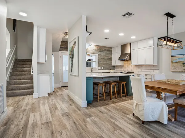 a open kitchen with stainless steel appliances granite countertop a refrigerator a stove and a wooden floors