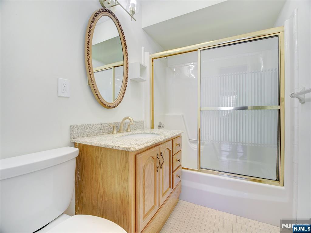 160 Overlook Avenue, Unit 17C Hackensack, NJ 07601 - Photo 11 of 30 a bathroom with a granite countertop sink a mirror and a shower
