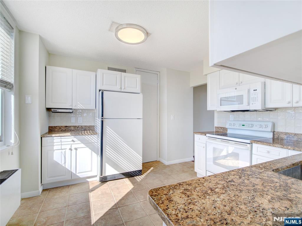 160 Overlook Avenue, Unit 17C Hackensack, NJ 07601 - Photo 22 of 30 a kitchen with granite countertop a refrigerator and a stove top oven