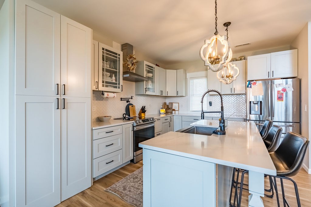3765 S Road Cadiz, KY 42211 - Photo 18 of 78 a kitchen with stainless steel appliances a table chairs and a chandelier