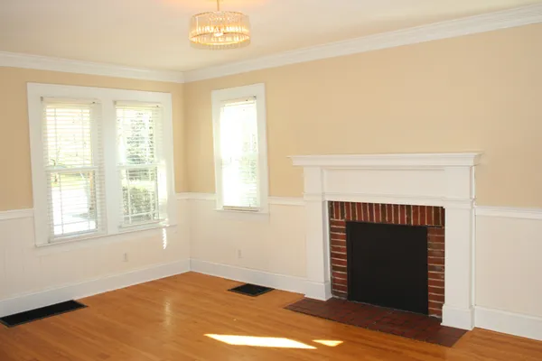 a view of empty room with wooden floor and fireplace