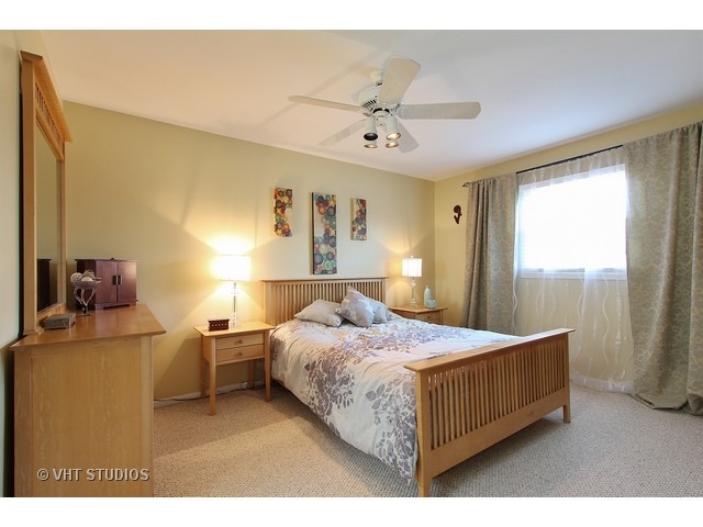 910 Dannet Road Buffalo Grove, IL 60089 - Photo 14 of 25 a bedroom with a bed and a chandelier