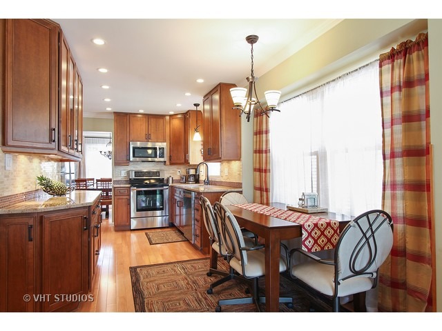 910 Dannet Road Buffalo Grove, IL 60089 - Photo 9 of 25 a dining hall with stainless steel appliances kitchen island granite countertop a table chairs and a refrigerator
